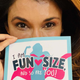 Anjali Bhimani holds up the cover of her self-help book over her face.